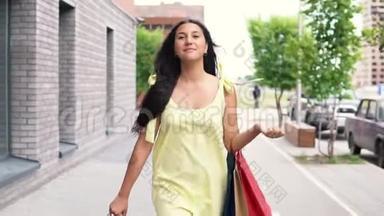 一个穿着黄色连衣裙的漂亮女孩在购物后走在街上，心情很好。 慢动作。 高清高清